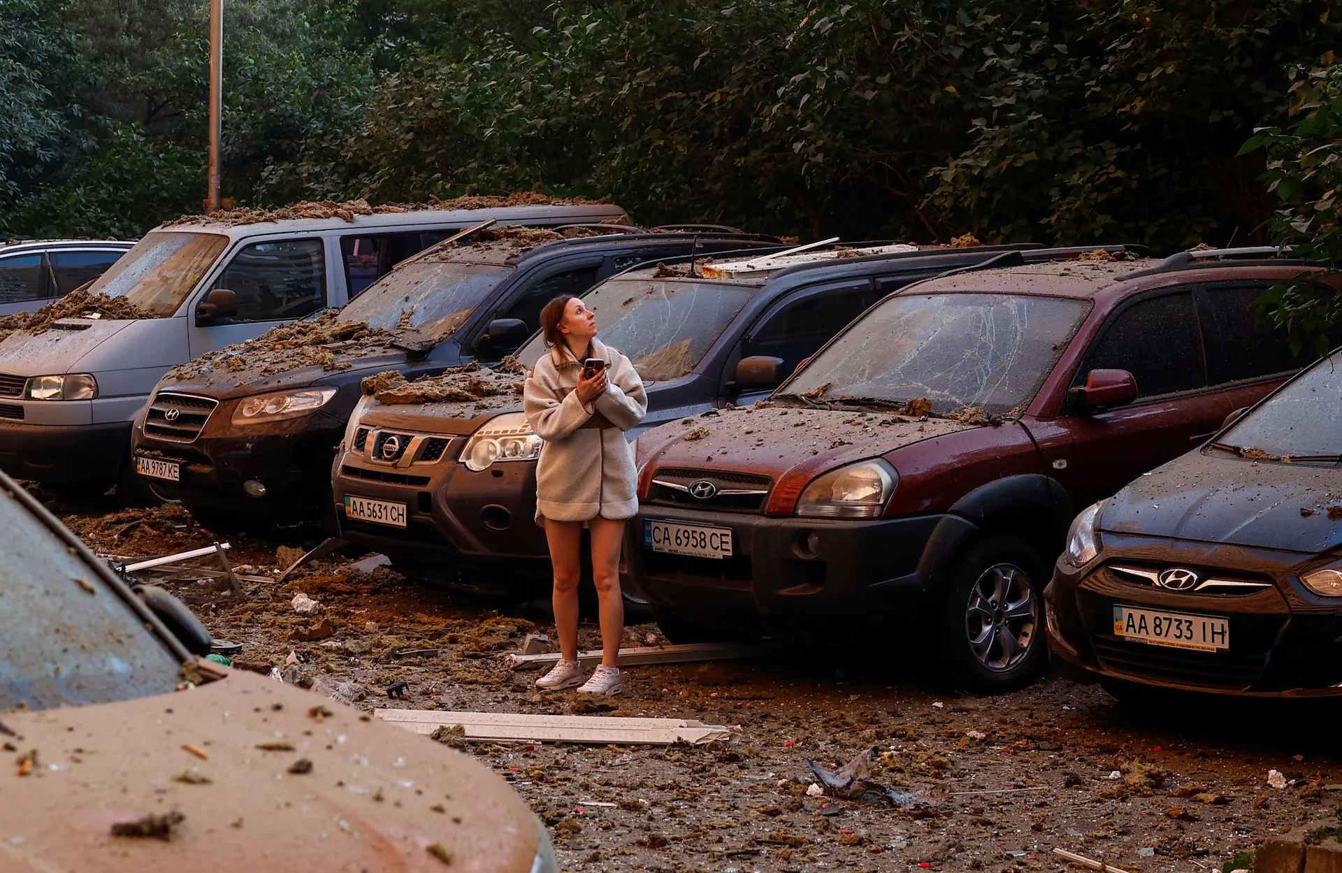 Мешканець стоїть біля пошкоджених автомобілів після російських ударів, в умовах російської агресії проти України, в Києві, Україна, 17 червня 2025 року.